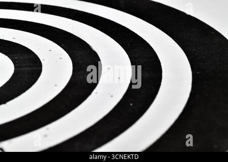 Gros plan d'un cercle noir et blanc avec des lignes blanches. Le cercle est flou et les lignes sont très fines. L'image a une sensation minimaliste à elle, avec Banque D'Images