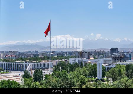 Kirghizistan, Bichkek - 12 juillet 2025 : vue aérienne du centre-ville avec un grand drapeau national sur le poteau, attractions, bâtiments modernes, arbres verts et dista Banque D'Images