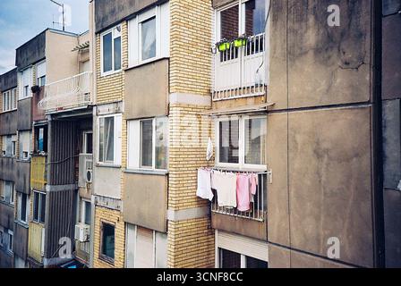 Photo analogique de linge suspendu pour sécher sur un balcon. Un aperçu tranquille de la vie quotidienne, encadré de lumière, de texture et de calme domestique. Banque D'Images