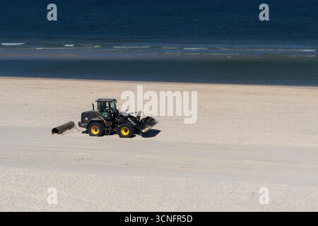 Kampen, Allemagne - 1er juillet 2025 : tracteur toilettant la plage de Heydorn sur l'île de Sylt en allemagne avec un grand tuyau de fer Banque D'Images