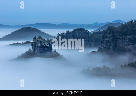 Vue sur la vallée sèche "kleiner Zschand" remplie d'une mer de nuages depuis la montagne Winterberg en Suisse saxonne, Allemagne. Banque D'Images