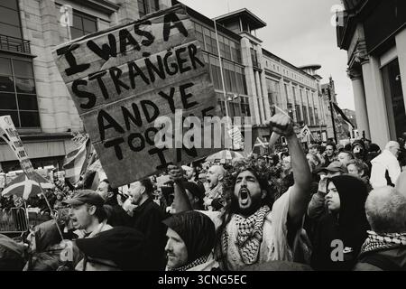 Un contre-manifestant à la manifestation anti-immigration « unité » à Glasgow brandit une pancarte Banque D'Images