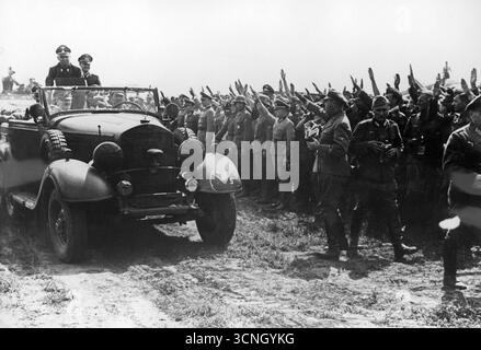 Seconde Guerre mondiale – Adolf Hitler et Gruppenfuhrer Julius Schaub (debout à gauche) dans une voiture portant l'insigne de la 45e division d'infanterie lors d'une visite à un aérodrome. Les soldats lui donnent le salut nazi, 1941 Banque D'Images