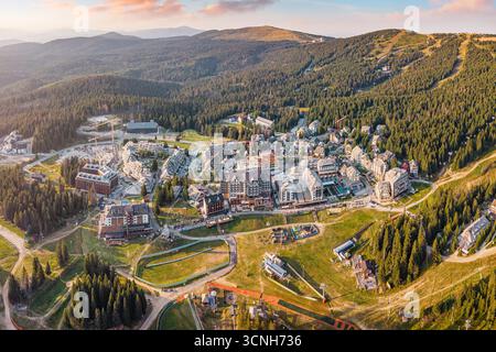 Superbe panorama aérien de la station de ski de Kopaonik en Serbie, avec des hôtels, des chalets et des pistes verdoyantes pendant un magnifique coucher de soleil Banque D'Images