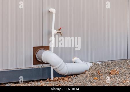 Robinet d'eau et tuyau sortant d'un mur de bâtiment, plomberie et système de drainage concept Banque D'Images