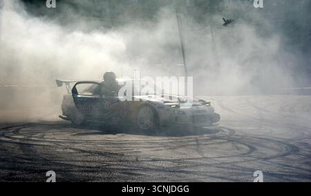 Sam Sam exécutant un impressionnant spectacle de dérive avec une BMW E30 325i à Budapest, produisant une fumée de pneu massive et divertissant la foule excitée Banque D'Images