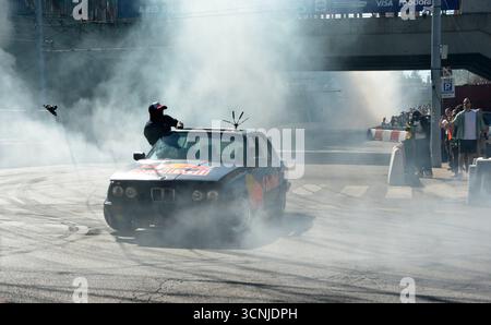 Sam Sam exécutant un impressionnant spectacle de dérive avec une BMW E30 325i à Budapest, produisant une fumée de pneu massive et divertissant la foule excitée Banque D'Images