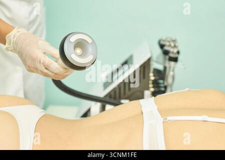 Femme sous traitement de la cellulite avec un équipement moderne non chirurgical en clinique thermale. Banque D'Images