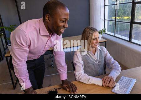 Divers collègues en tenue professionnelle collaborant sur le clavier, smartphone au bureau dans le bureau Banque D'Images