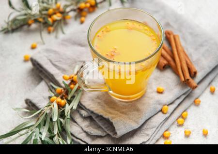 Boisson chaude à l'argousier servant des ingrédients sains sur une serviette en lin Banque D'Images