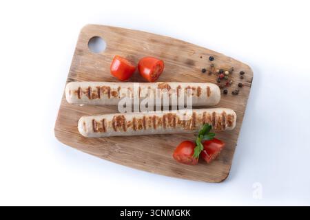 Saucisses Bratwurst grillées avec tomates cerises et persil isolées sur fond blanc Banque D'Images