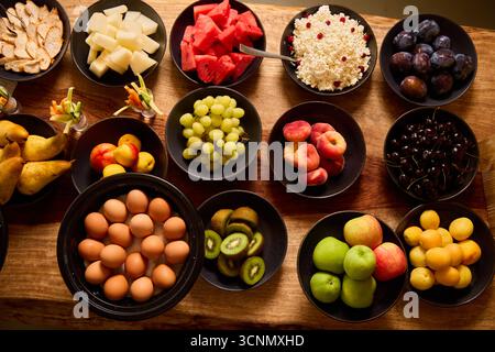 Affichage de fruits et d'œufs sur une table en bois lors d'un rassemblement vibrant Banque D'Images