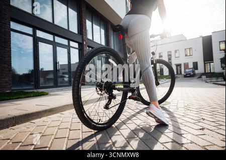Gros plan de femme dans des vêtements de sport et des baskets vélo d'équitation Banque D'Images
