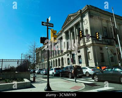 Philadelphie, Pennsylvanie, États-Unis - 29 avril 2025 : une rue animée de Philadelphie avec une grande façade de bibliothèque historique, des voitures bordant le trottoir. Banque D'Images
