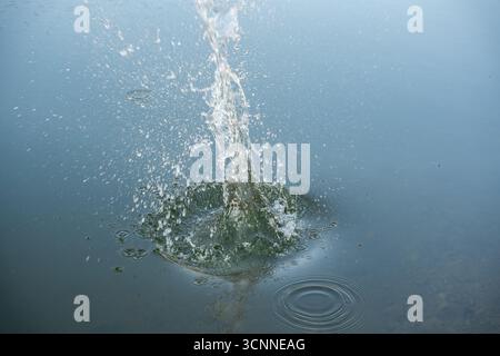 Ondulations circulaires de l'eau et effet bulles. Ondulations d'eau et gouttelettes rondes sur fond bleu de motif de texture de mer. Mouvement liquide, effet anneau, cercle Banque D'Images