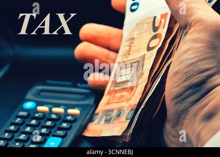 Gros plan de la main de l'homme d'affaires à l'aide de la calculatrice pour les taxes et les piles de billets en euros Banque D'Images