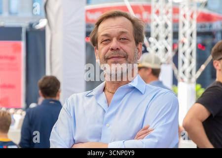 Portrait d'un homme confiant âgé de 50-55 ans dans une chemise bleue contre une foule de gens Banque D'Images