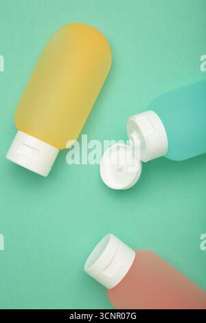 Bouteilles de voyage avec des cosmétiques de soins du corps sur fond de menthe. Vue de dessus Banque D'Images