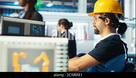 Directeur d'usine photovoltaïque montrant les corrections d'ingénieur à faire pour réparer les systèmes défectueux. Homme montrant les mises à niveau de techniciens d'usine de fabrication de panneaux solaires nécessaires pour réduire les temps d'arrêt, caméra B. Banque D'Images