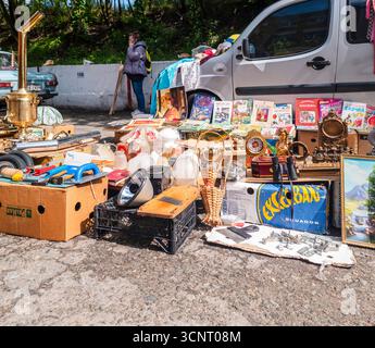 Kiev, Ukraine 11 mai,2025, affichage de marché aux puces de rue avec des antiquités vintage, vieux livres, outils rétro, horloges, lampes, et les articles de décoration de la maison disposés sur le trottoir près d'une camionnette à la lumière du jour Banque D'Images