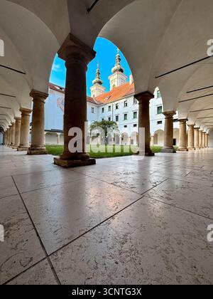 Des colonnes de pierre et des arches voûtées bordent la cour du monastère franciscain historique près de Mariahilferkirche, qui fait partie d'un complexe centenaire de Gr Banque D'Images