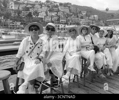 Un groupe de femmes visitant l'île de Santa Catalina au large des côtes de la Californie du Sud pose pour un portrait de groupe sur la jetée d'Avalon, Californie, États-Unis Banque D'Images