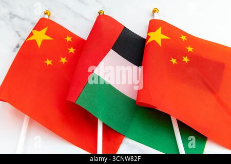 Le drapeau national des Émirats arabes Unis sur le mât du drapeau entre le drapeau national chinois. Un concept de relations entre la Chine et les Émirats arabes Unis. Banque D'Images