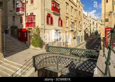 Rue avec des maisons historiques incroyables avec des balcons en bois colorés à la Valette, capitale de Malte, pont de Victoria Gate Banque D'Images