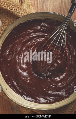 Un bol de pâte au chocolat, un fouet pour fouetter, cuire au four, structure et consistance, fait maison, vue de dessus, personne Banque D'Images