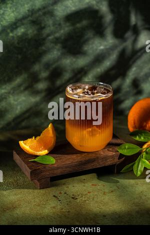 Un café glacé rafraîchissant servi dans un verre à l'aspect bicolore distinct, avec jus d'orange éclatant et café riche, garnis de Banque D'Images