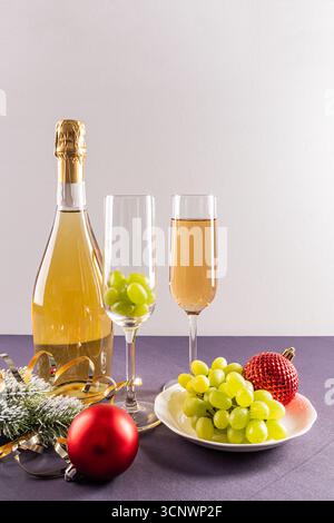 Célébrez la tradition espagnole avec le rituel du nouvel an de manger douze raisins pour la bonne chance. Une bouteille de champagne et des ornements décoratifs complètent th Banque D'Images
