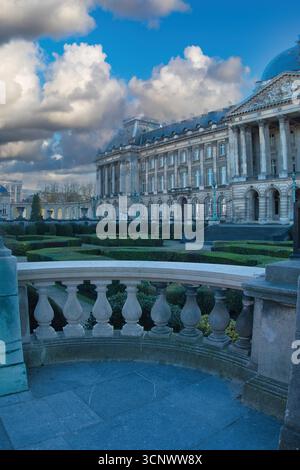 Palais de Bruxelles depuis le jardin - Une vue verticale du Palais Royal de Bruxelles et de ses jardins bien entretenus, avec des nuages spectaculaires dans un ciel bleu. Banque D'Images