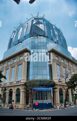 Immeuble de bureaux moderne avec façade en verre réfléchissant - Une photo à angle bas d'un bâtiment élégant et contemporain avec un toit incurvé en panneaux de verre et une pierre Banque D'Images
