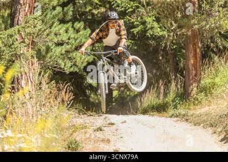 Un VTT parcourt un sentier forestier à Zermatt, Valais, Suisse, mettant en valeur son talent et son aventure au milieu de paysages alpins, mettant en valeur le Thri Banque D'Images