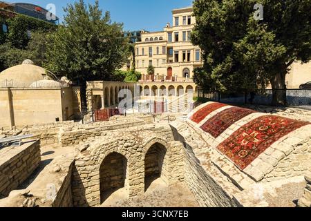 Ruines de caravansérail et tapis traditionnels à Icherisheher, la vieille ville de Bakou, Azerbaïdjan Banque D'Images