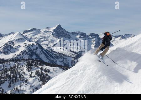 Un skieur navigue une descente palpitante sur les pentes enneigées des Pyrénées. Entourés de montagnes majestueuses, ils sculptent de la poudre fraîche, de l’incardyin Banque D'Images