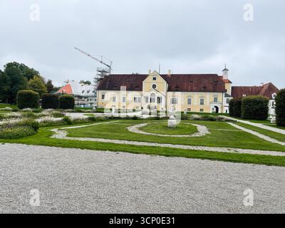 Oberschleissheim, Allemagne - 25 septembre 2022 : manoir historique allemand du palais Schleissheim avec jardins formels et chemins de gravier sous un ciel couvert. Banque D'Images