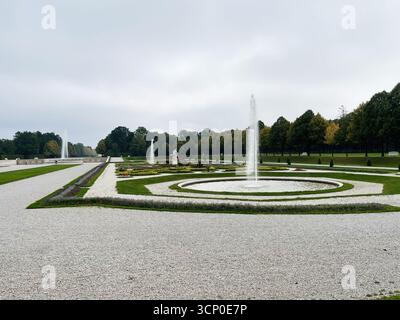 Oberschleissheim, Allemagne - 25 septembre 2022 : scène de jardin sereine du Palais Schleissheim allemand avec fontaines, chemins de gravier, haies taillées et statu Banque D'Images