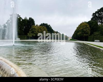 Oberschleissheim, Allemagne - 25 septembre 2022 : scène de parc tranquille dans le palais de Schleissheim Allemagne avec fontaine d'eau, jardins ornés et dista Banque D'Images
