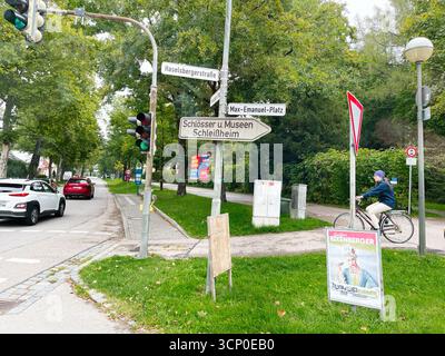 Oberschleissheim, Allemagne - 25 septembre 2022 : une scène de rue en Allemagne avec des panneaux, des feux de signalisation, un cycliste et un environnement verdoyant. Banque D'Images
