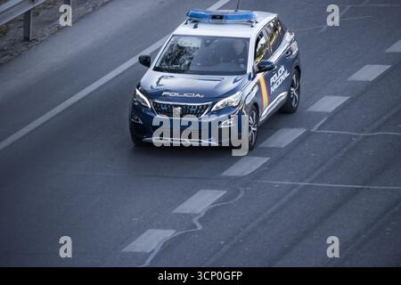 Une voiture de police locale se déplaçant dans la voie de gauche avec des feux de détresse bleus pendant une opération de circulation sur le M-30 Banque D'Images