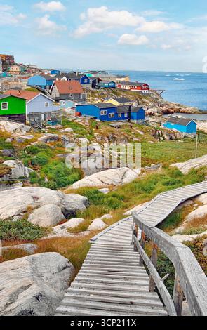 Village de pêcheurs traditionnel du Groenland Ilulissat avec des icebergs en arrière-plan. Banque D'Images