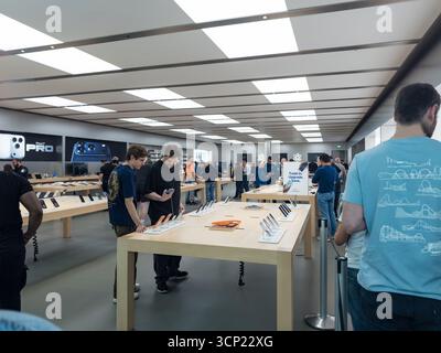 Les clients parcourent et testent les appareils dans un Apple Store moderne très fréquenté avec un éclairage lumineux et un design élégant Apple newcastle metrocentre Banque D'Images