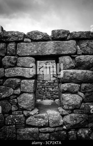 Fenêtres des maisons en pierre dans les ruines du Machu Picchu, une citadelle inca située dans les Andes péruviennes à 2 400 mètres d'altitude. Banque D'Images