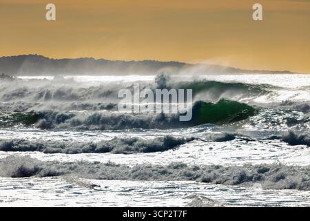 Photographie de vagues de la mer de Tasman s'écrasant sur Jones Beach contre un ciel orange près de la ville de Kiama Downs dans la région d'Illawarra en Nouvelle-Galles du Sud. Banque D'Images