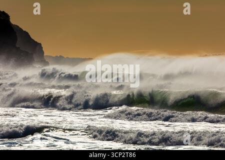 Photographie de vagues de la mer de Tasman s'écrasant sur Jones Beach contre un ciel orange près de la ville de Kiama Downs dans la région d'Illawarra en Nouvelle-Galles du Sud. Banque D'Images