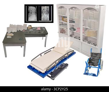 Lit d'hôpital dans un cabinet de médecin avec des radiographies et un fauteuil roulant entouré de fournitures médicales Banque D'Images