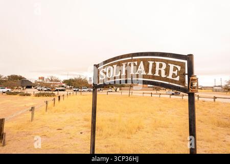 La colonie désertique isolée de Solitaire en Namibie présente un panneau affichant le nom de la ville, situé contre des dunes de sable doré et des montagnes escarpées Banque D'Images