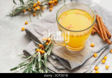 Boisson chaude à l'argousier servant des ingrédients sains sur une serviette en lin Banque D'Images