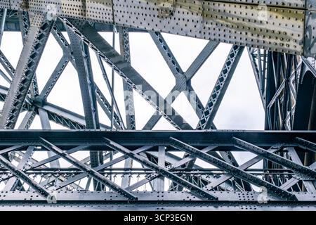 Vue rapprochée de la structure en treillis métallique complexe et des rivets de l'emblématique pont Dom Luis I à Porto, Portugal. Motifs géométriques, détails industriels Banque D'Images